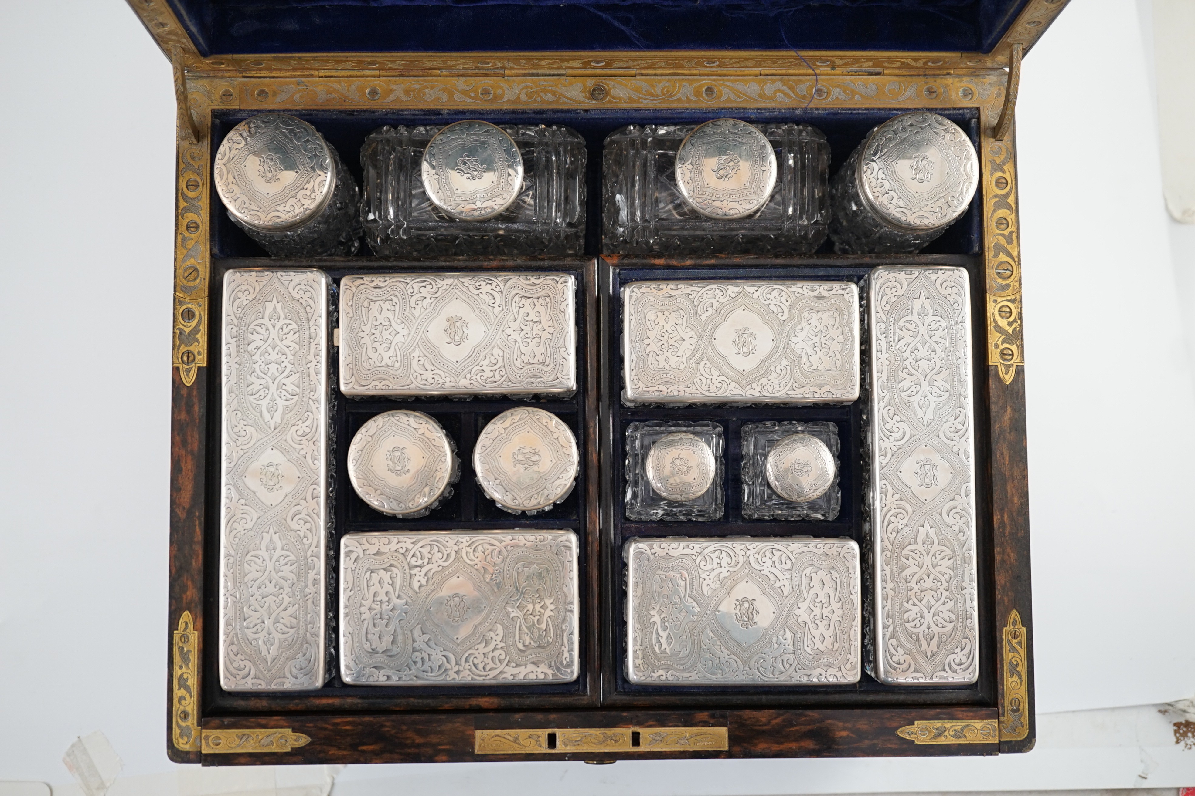 A Victorian brass mounted coromandel wood toilet box, containing fourteen engraved silver mounted toilet jars, by Thomas Whitehouse, London, 1865